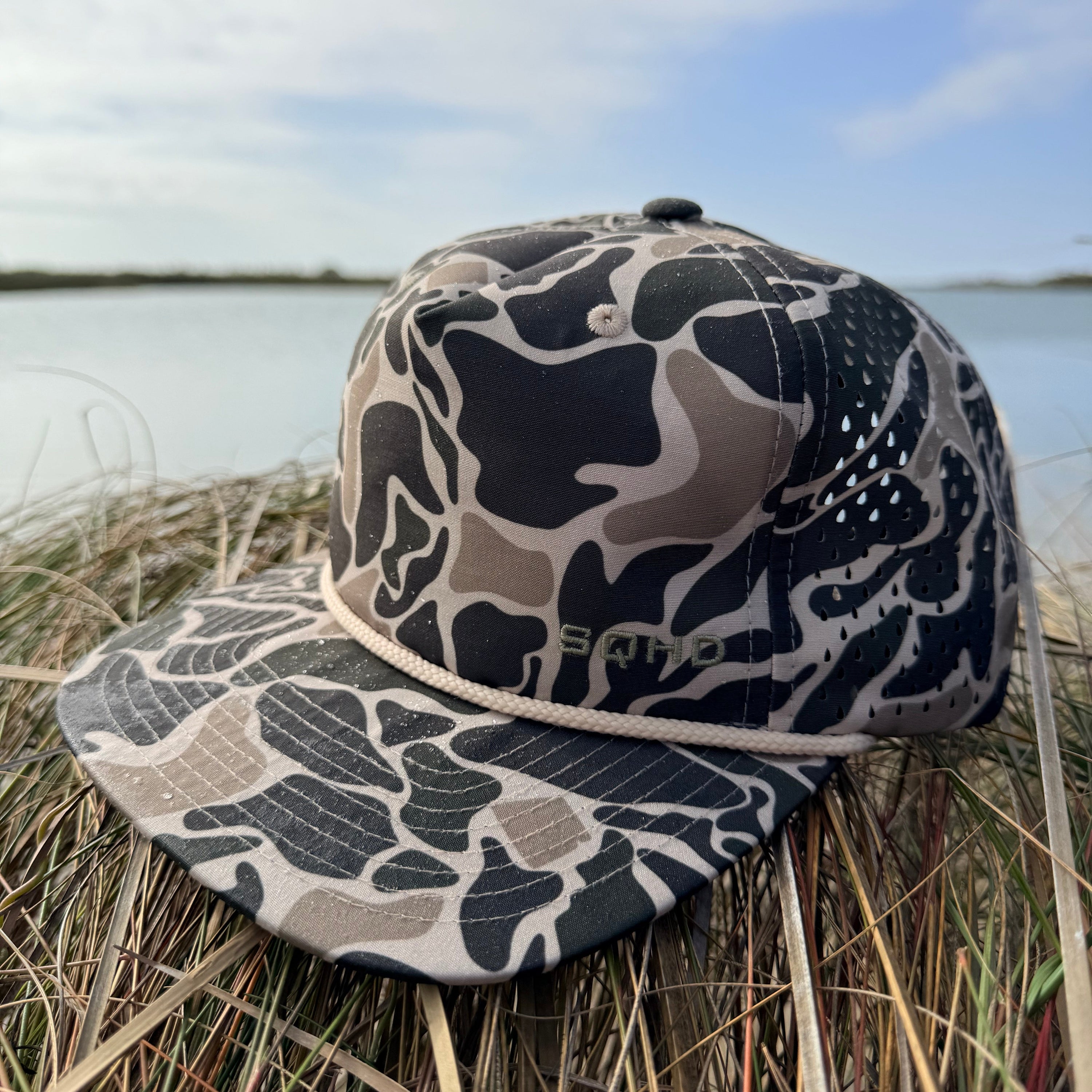 Camouflage hat on a grassy surface with a blurred background